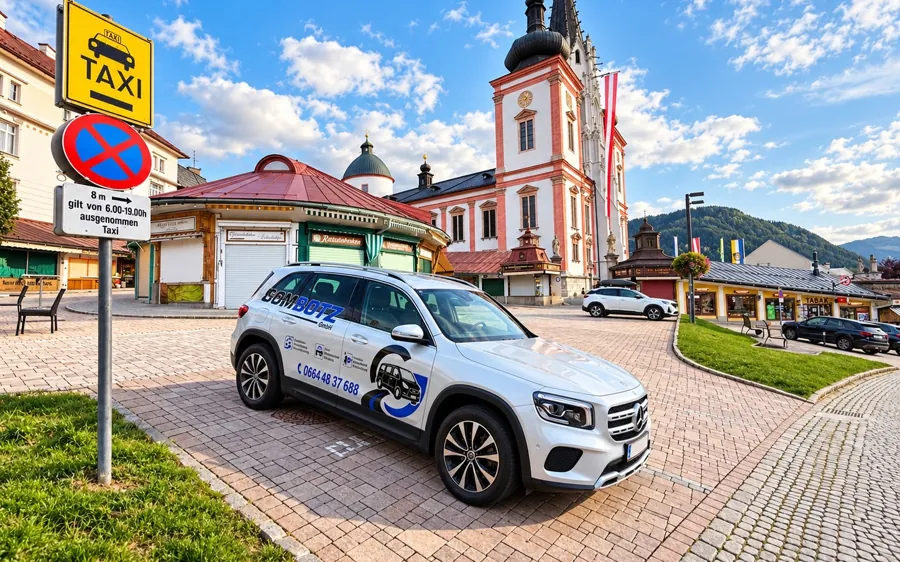 Weißer Mercedes GLB mit GOMBOTZ-Beklebung vor der Basilika Mariazell